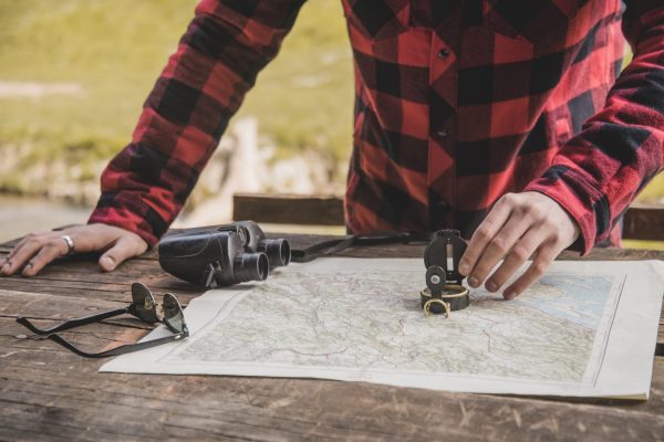 close-up-hand-with-compass-map